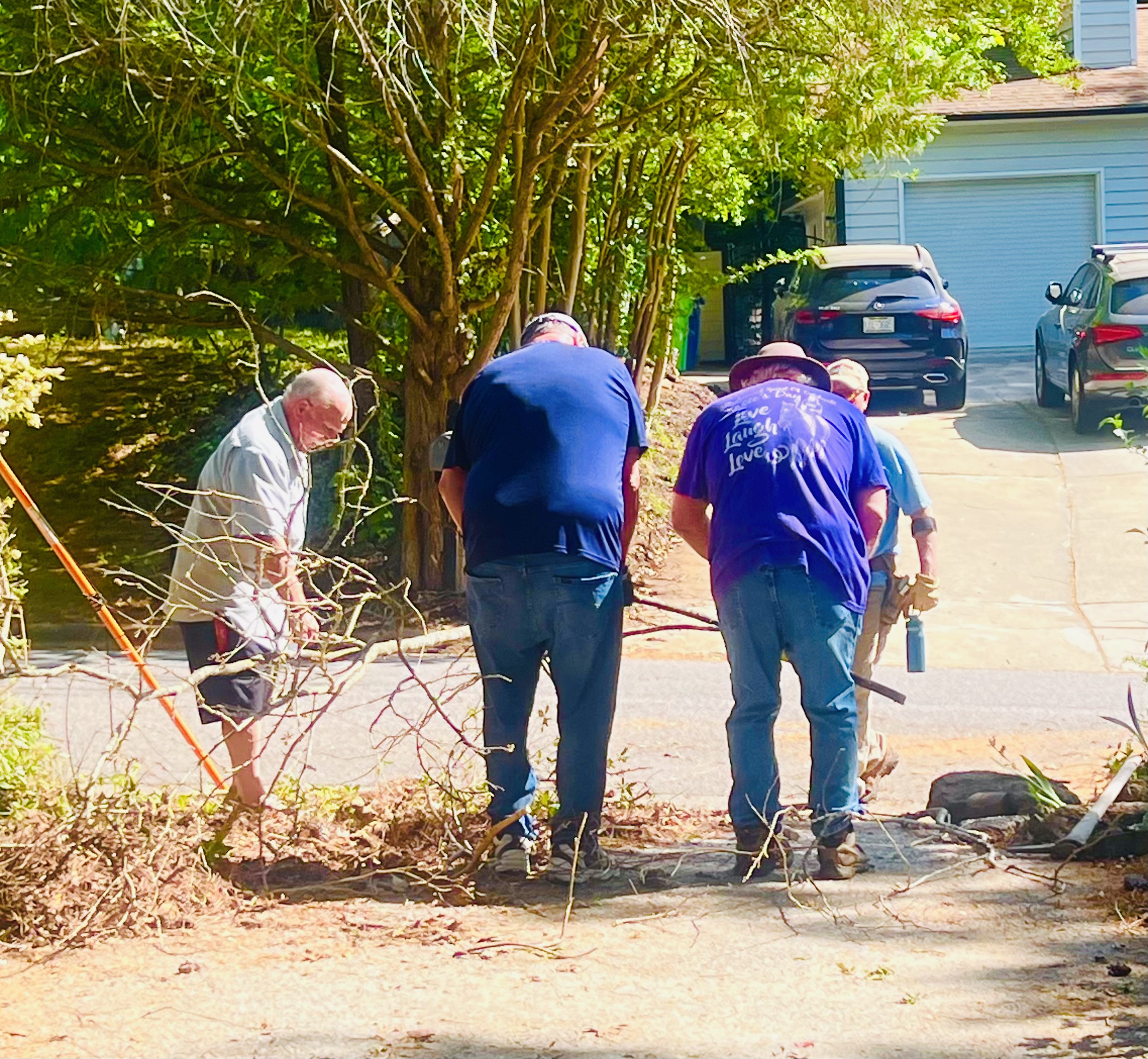 Men of Purpose volunteers cleaning up a driveway